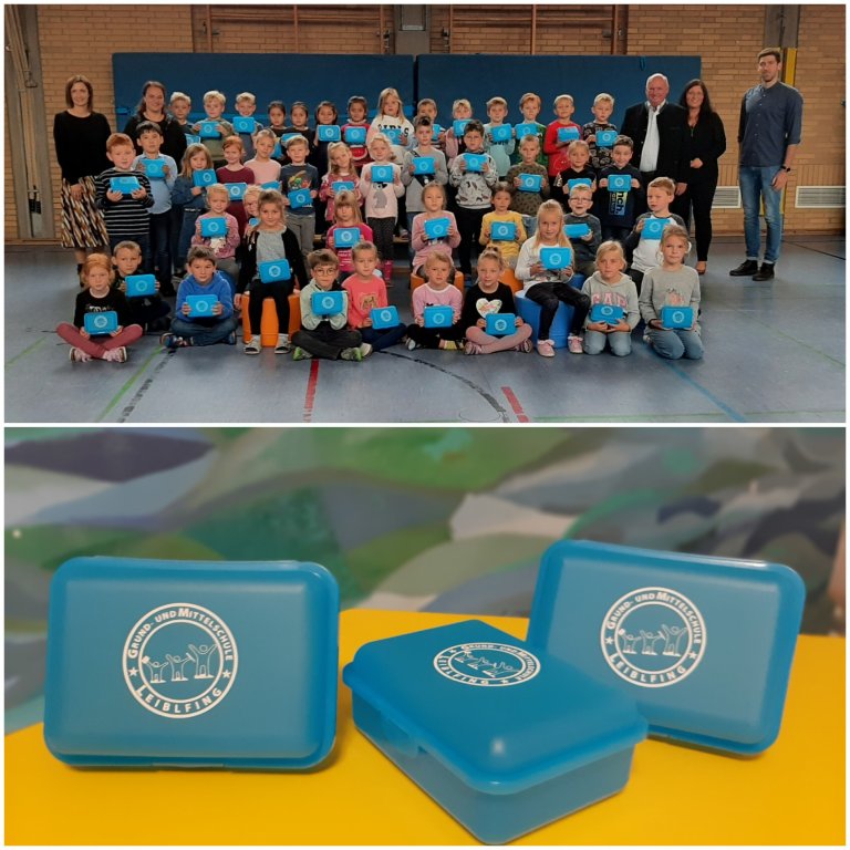 Gruppenfoto mit Erstklässler/innen und Pausenboxen als Geschenk in der Hand